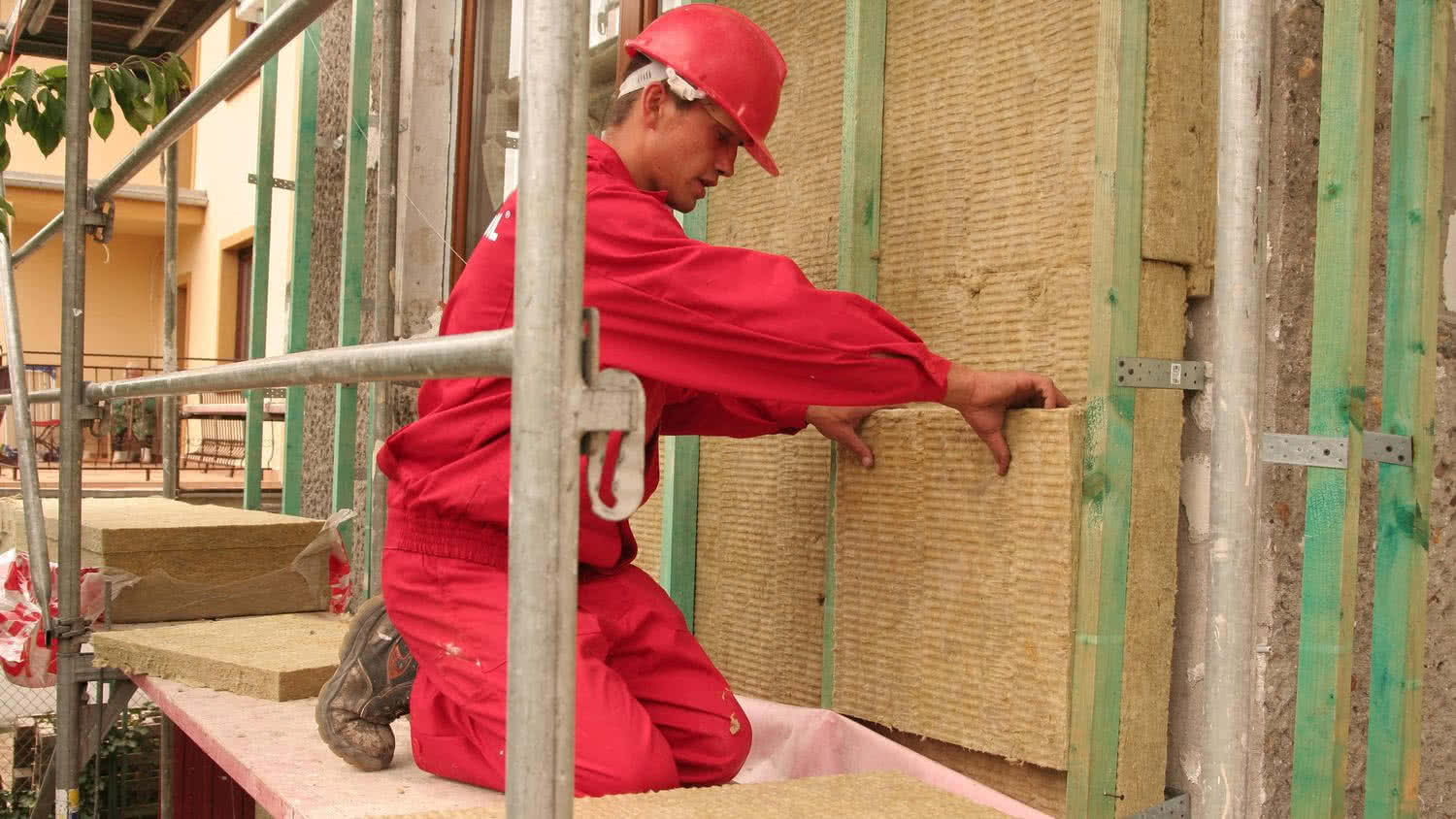 Ocieplanie budynku metodą lekką suchą, mocowanie płyt z wełny mineralnej. Ocieplanie budynku metodą lekką suchą, mocowanie płyt z wełny mineralnej.